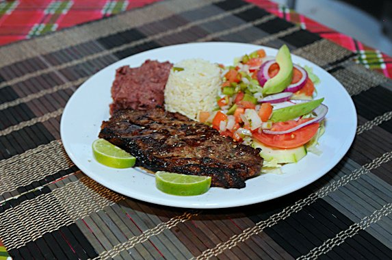Carne asada - grilled steak with rice, beans and salad